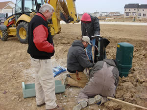 Placement crews/splicing technician adjusting pedestal on CenturyTel FTTH project.